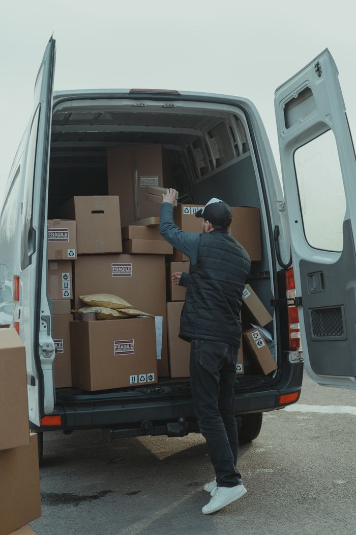 The Art of Drawing Readers In: Your attractive post title goes here A courier organizing boxes in a delivery van for shipment on a cloudy day.